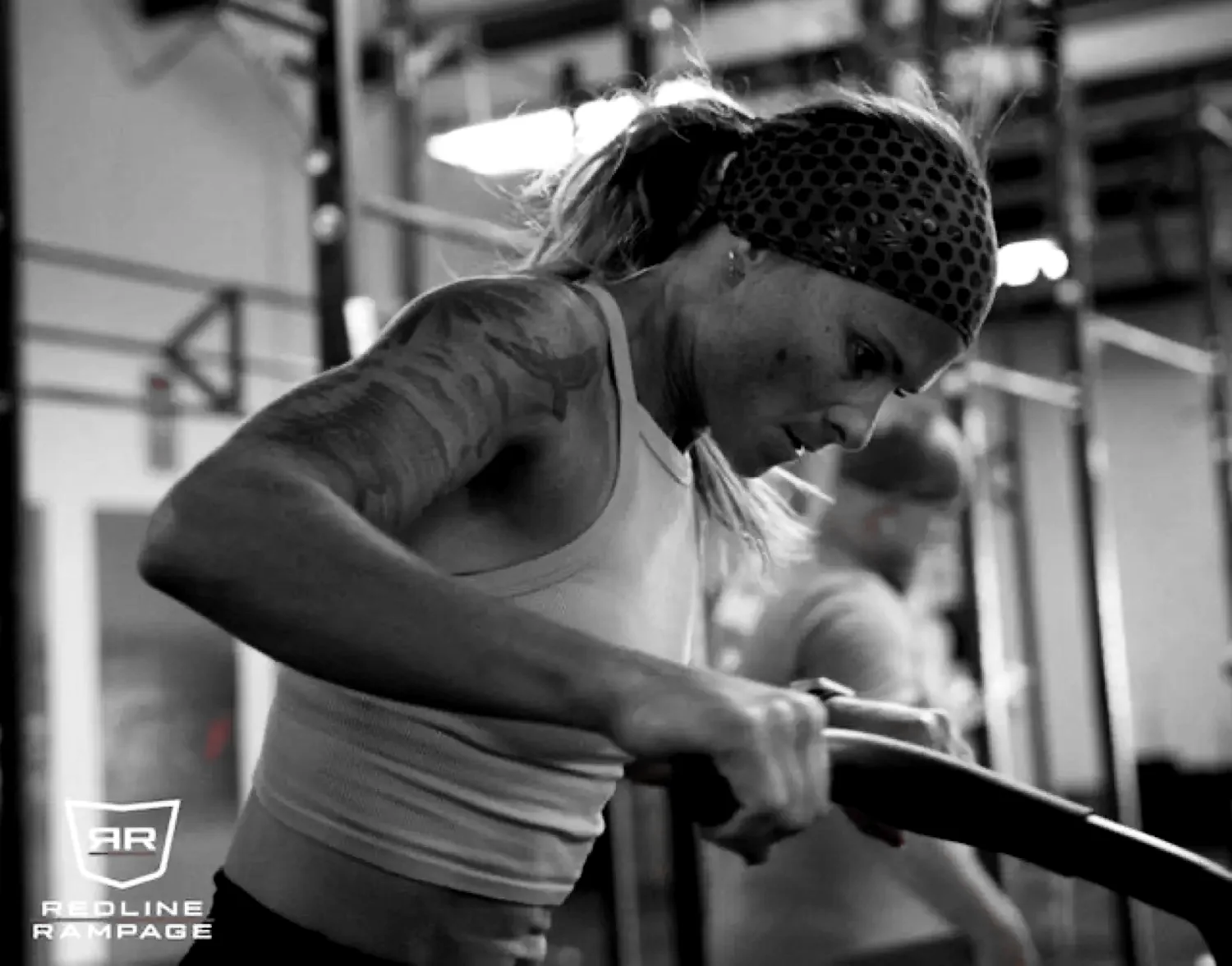 A Redline athlete driving hard on the rower during HYROX training