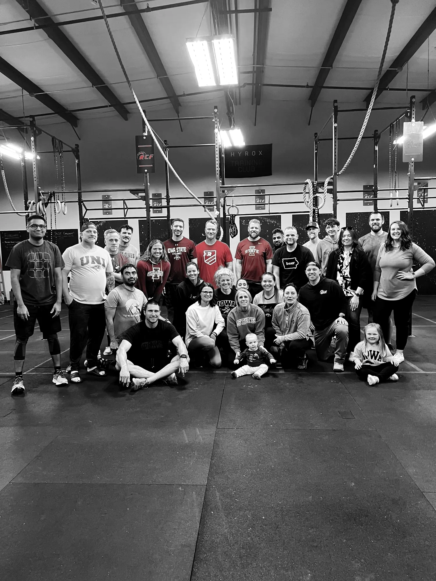 Redline members, coaches and a few kids together on the gym floor in Waukee, under the HYROX Training Club banner