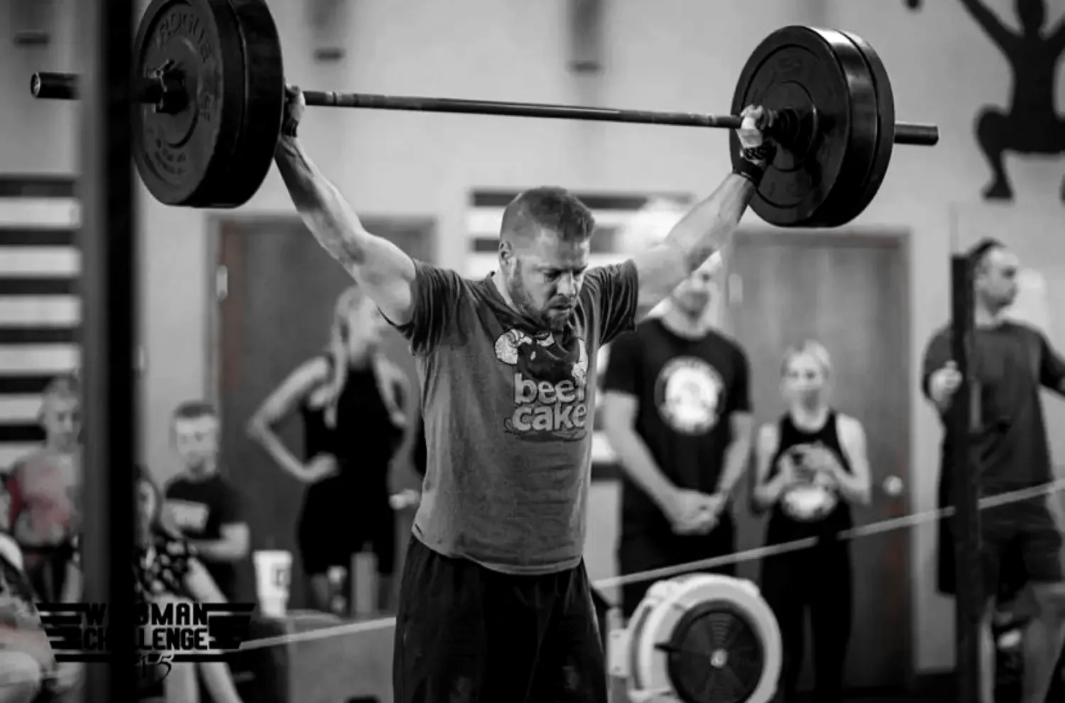 A Redline athlete locking out a barbell overhead at our functional fitness gym in Waukee
