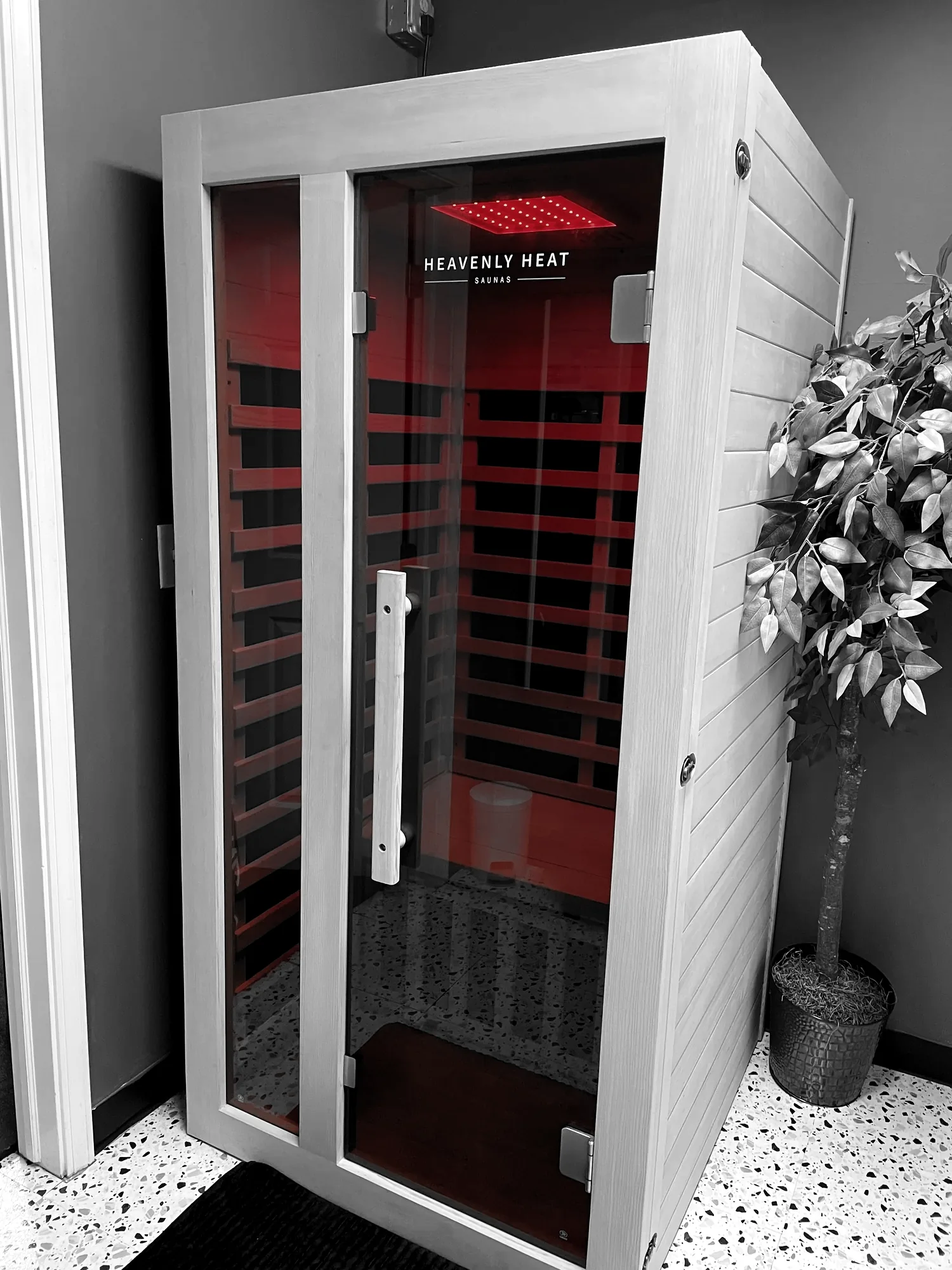 The sauna at Redline Fitness Collective in Waukee, glowing red with its door closed